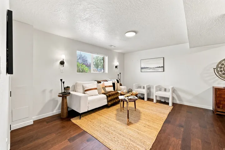 Wood-finish flooring with a textured ceiling and recessed lighting