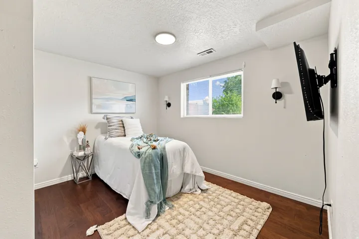 Rich wood-finish flooring, recessed ceiling light, and window with blinds