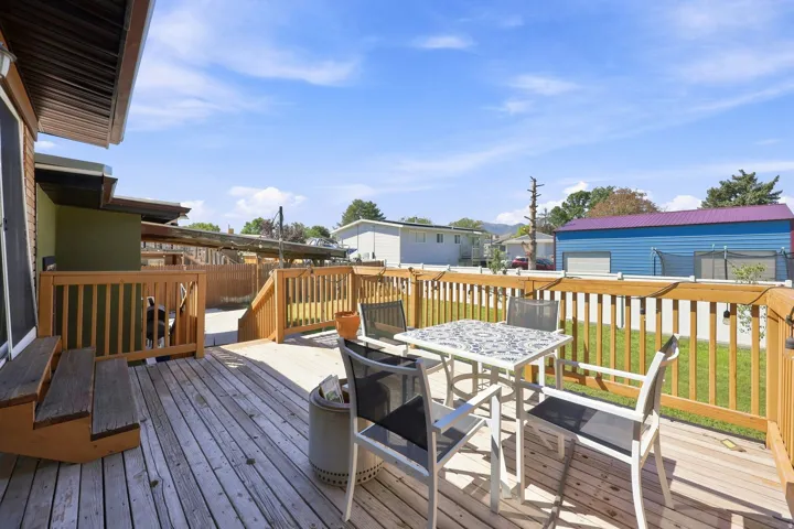 Expansive wood deck with a built-in railing system, integrated steps, and string lighting