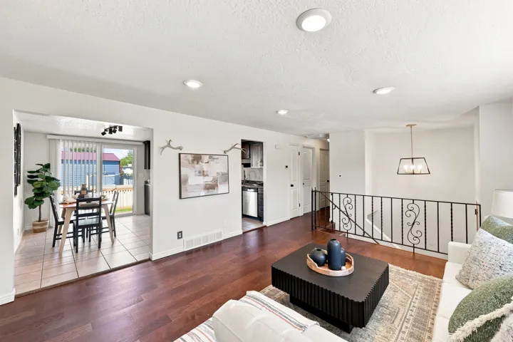 Hardwood flooring, recessed lighting, and a decorative wrought iron railing