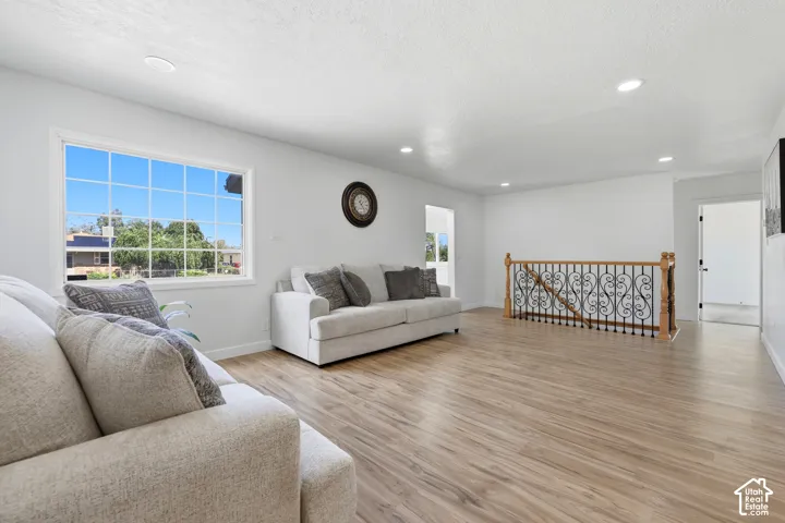 Recessed lighting, wood-finish flooring, and a large grid-pattern window