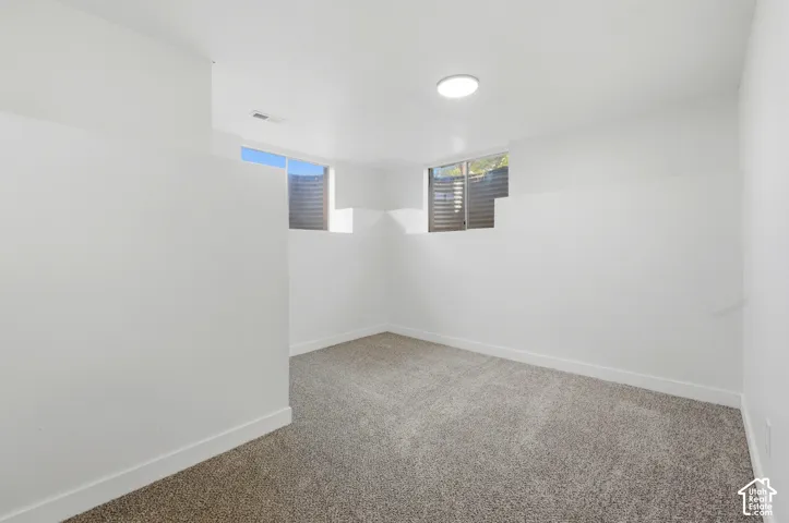 Neutral wall paint, recessed lighting, and soft carpet flooring