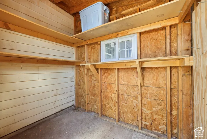 Built-in wooden shelving, a white-framed window, and wood-paneled walls