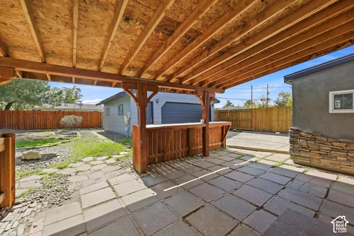 Covered patio featuring wood beams and a built-in bar