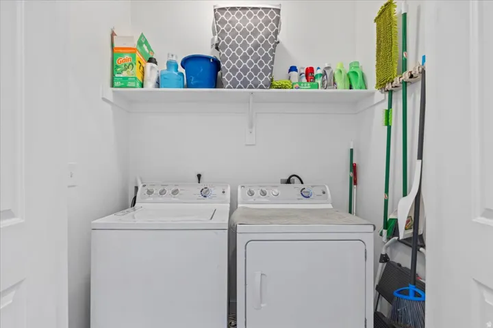 Dedicated laundry area with upper shelving and white walls