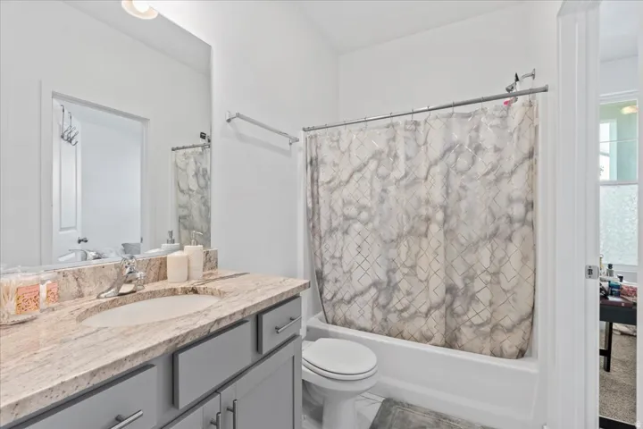 Bathroom featuring a vanity with a light-toned countertop, integrated sink, and gray cabinetry