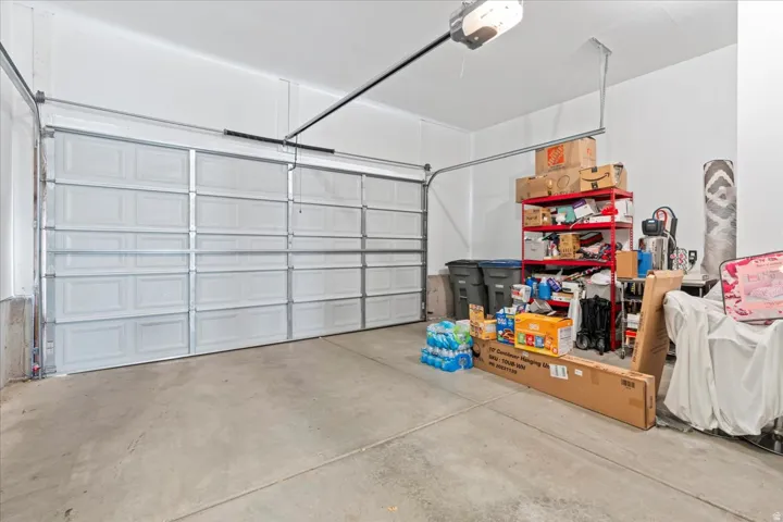 Attached garage featuring a panel garage door, concrete flooring, and an automatic garage door opener