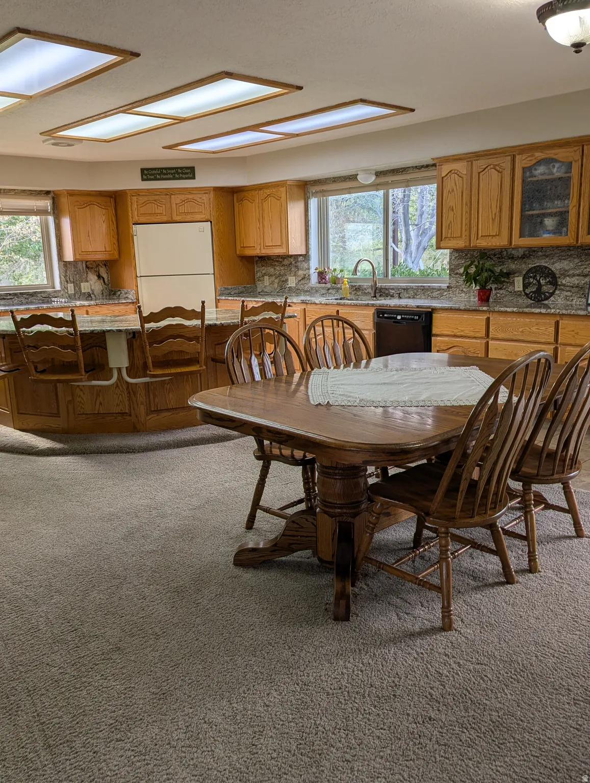 U-shaped kitchen with wood cabinetry, granite countertops, and recessed lighting