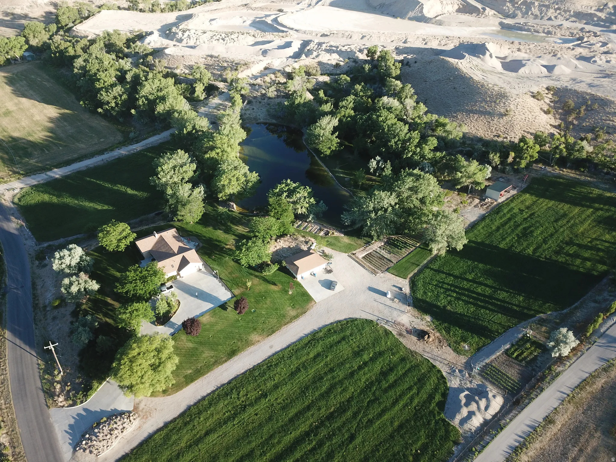 Expansive property featuring a residence, detached structure, and a pond