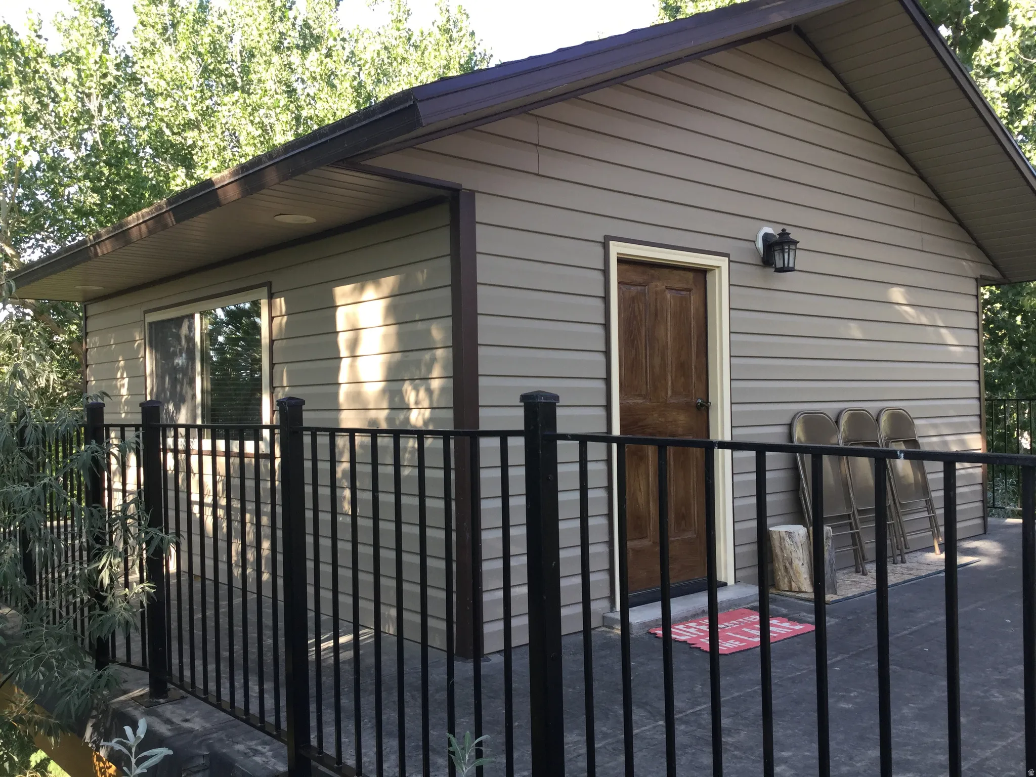 Exterior building featuring horizontal siding and a wood-finish entry door, complemented by an outdoor light fixture
