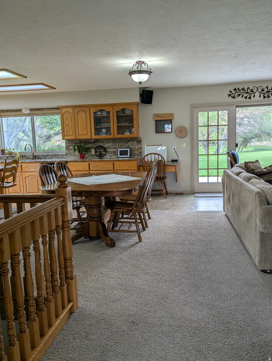 Kitchen featuring wood-finish cabinetry, stone-look countertops, and an undermount sink