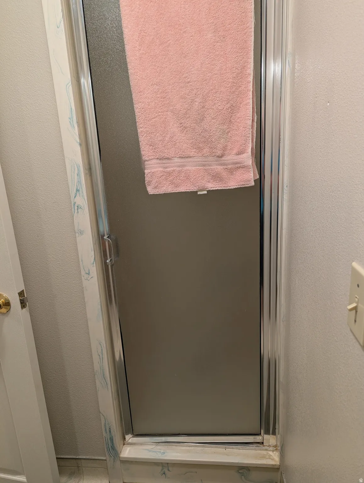 Shower enclosure with frosted glass panels and chrome-finish framing