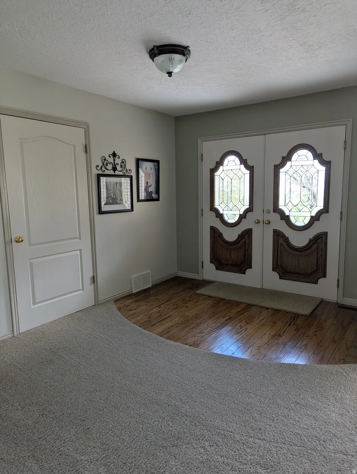 Double entry doors with decorative glass panels and wood-finish accents