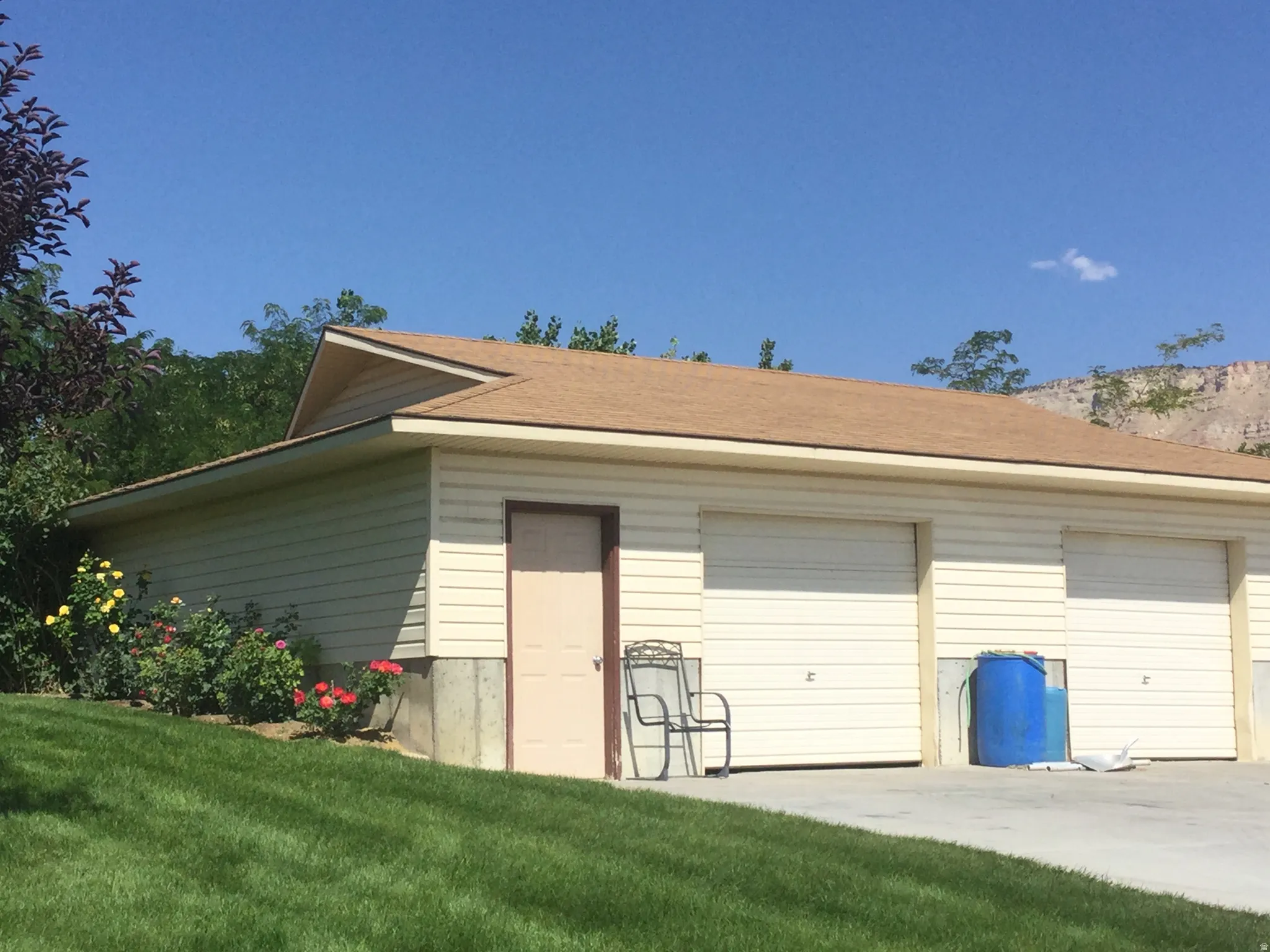 Garage structure with horizontal siding, two overhead garage doors, and a side entry door
