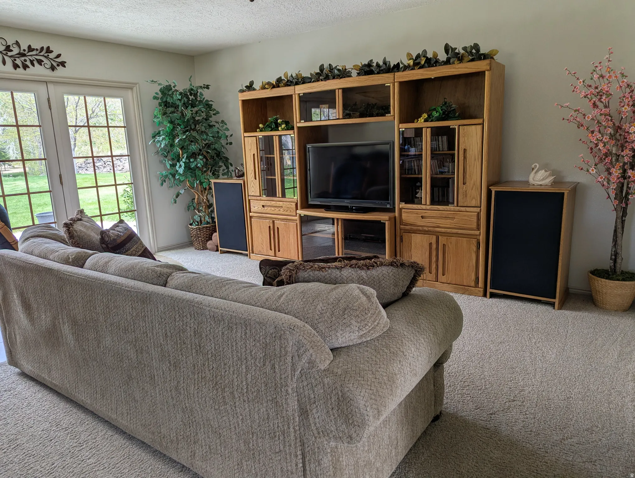 Light-colored wall-to-wall carpeting, white interior walls, and double glass-paned French doors