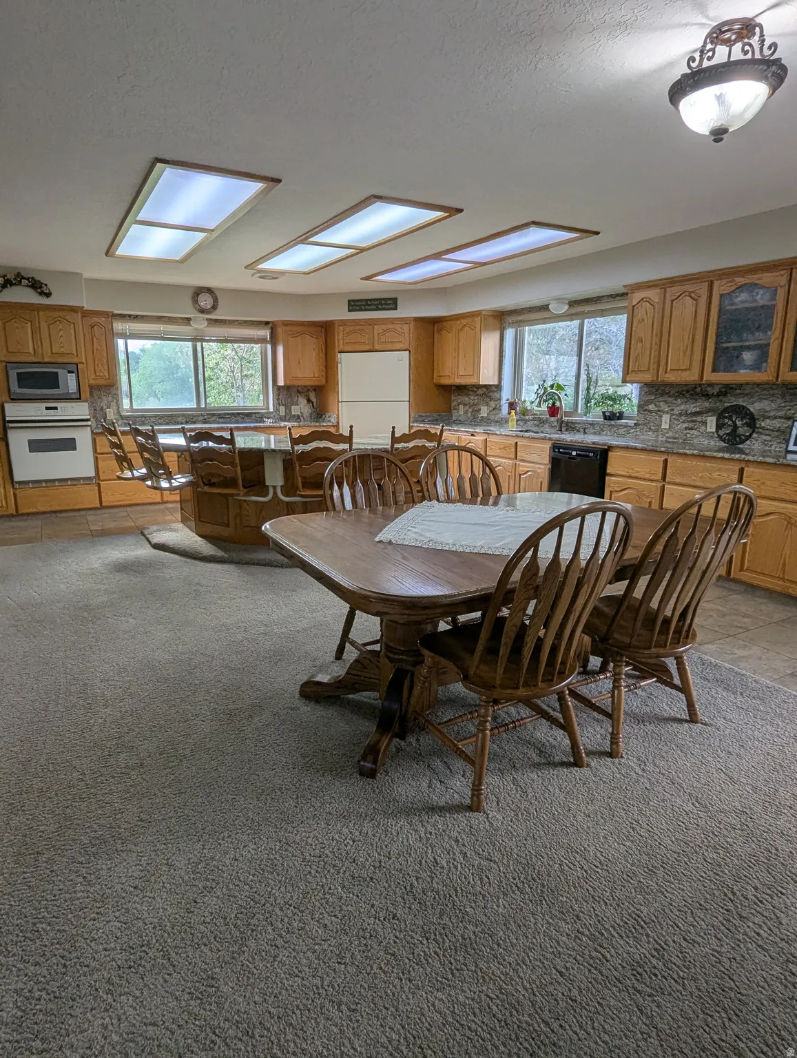 Kitchen featuring wood cabinetry, integrated appliances, stone countertops, and recessed lighting