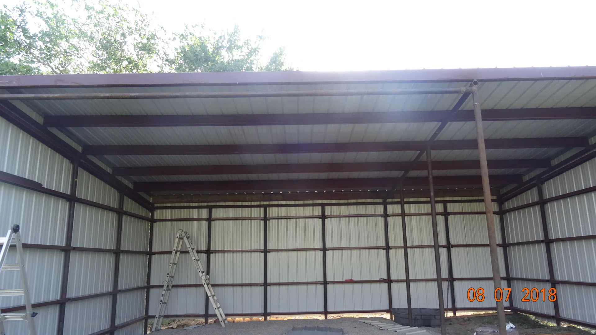 Steel-framed structure featuring a corrugated metal roof and walls