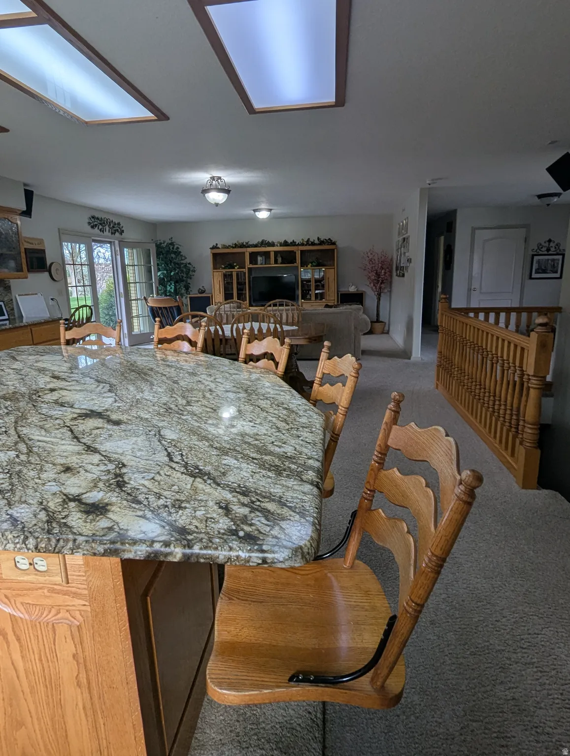 Kitchen island featuring a polished stone countertop, wood cabinetry, and built-in seating