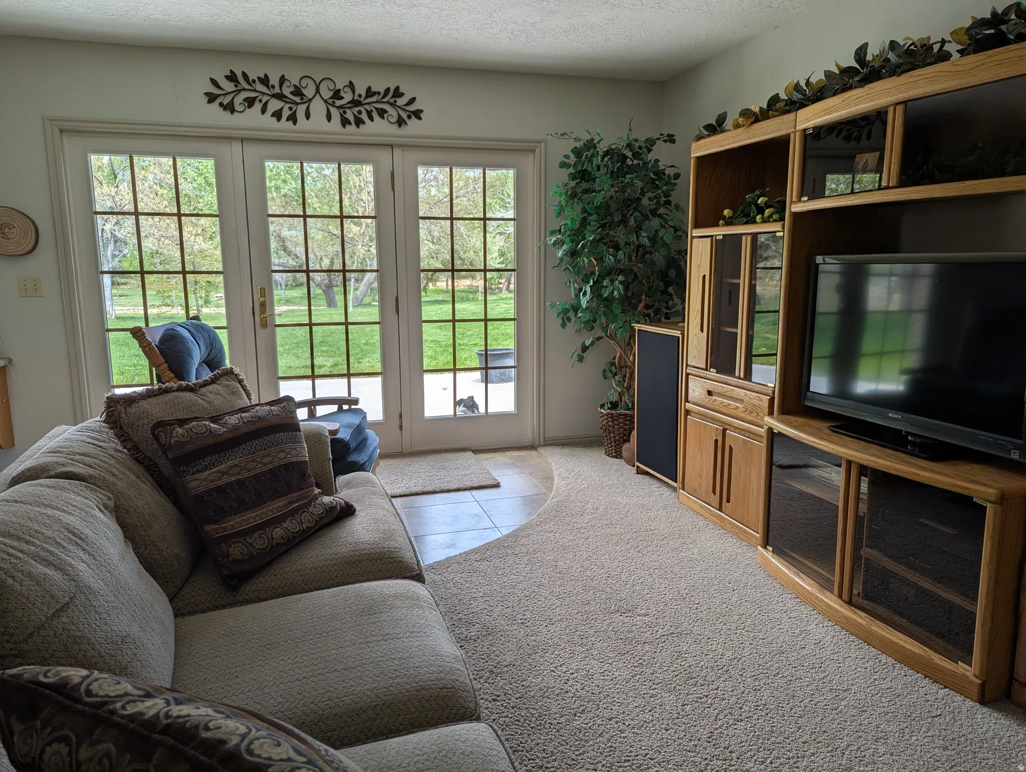 Built-in entertainment center with wood cabinetry, glass-paned doors, and enclosed shelving