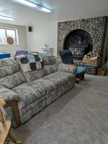 River rock fireplace surround with an arched opening, featuring a wood-burning stove
