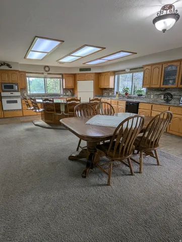 Kitchen featuring wood cabinetry, integrated appliances, stone countertops, and recessed lighting