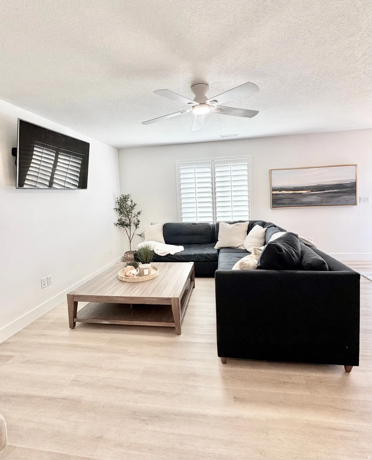 Recessed lighting, wood-finish flooring, white plantation shutters, and a ceiling fan with integrated lighting