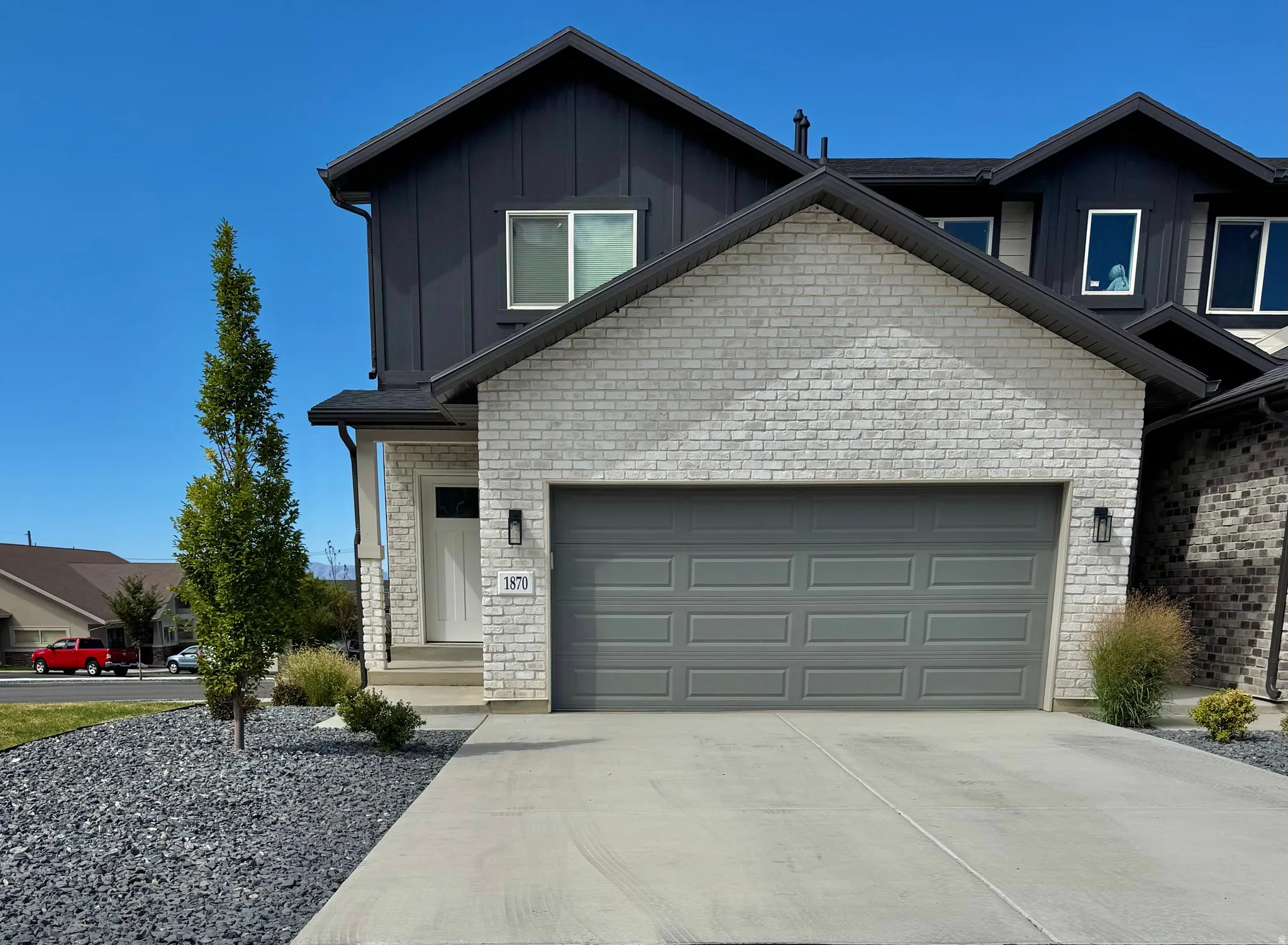 Contemporary exterior with light-toned brick and dark vertical siding