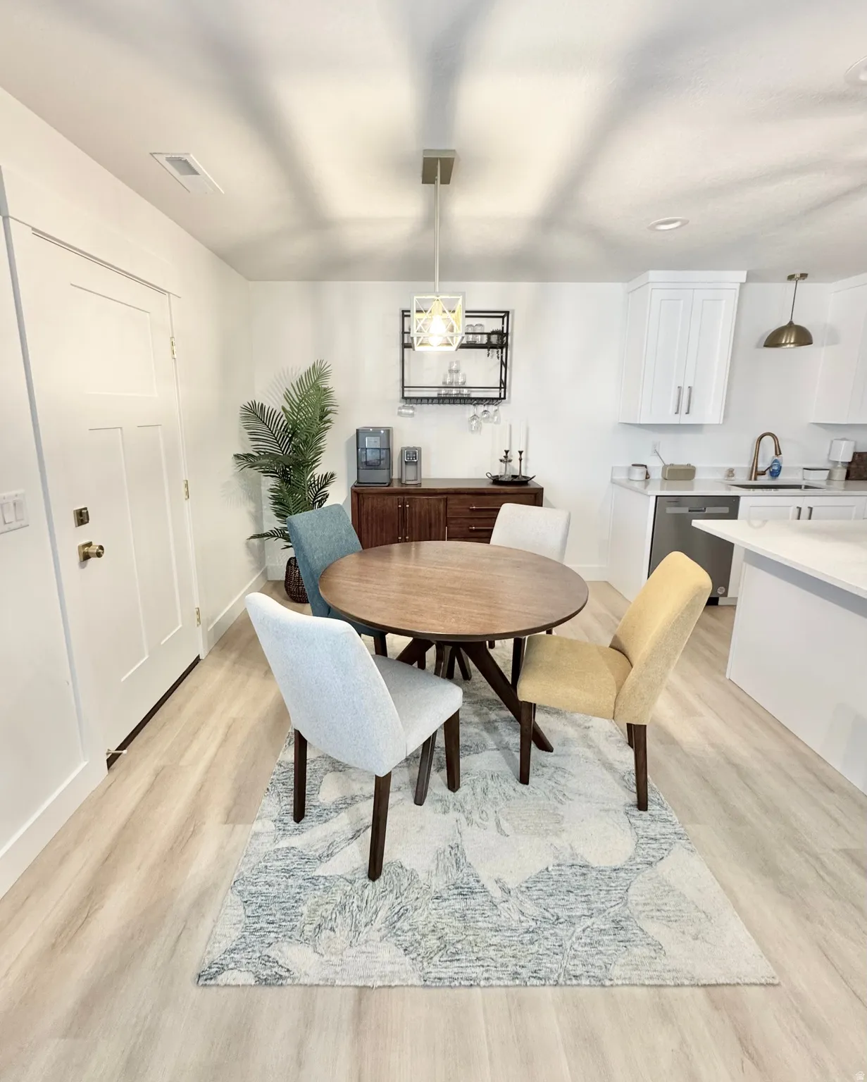 Wood-finish flooring, white walls, built-in cabinetry, and a modern rectangular pendant light
