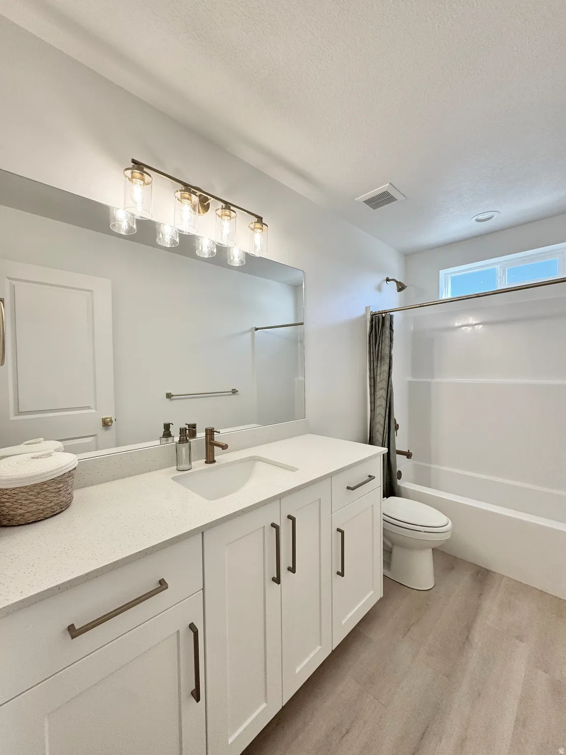 Double vanity with white cabinetry, bronze hardware, and light-colored countertops