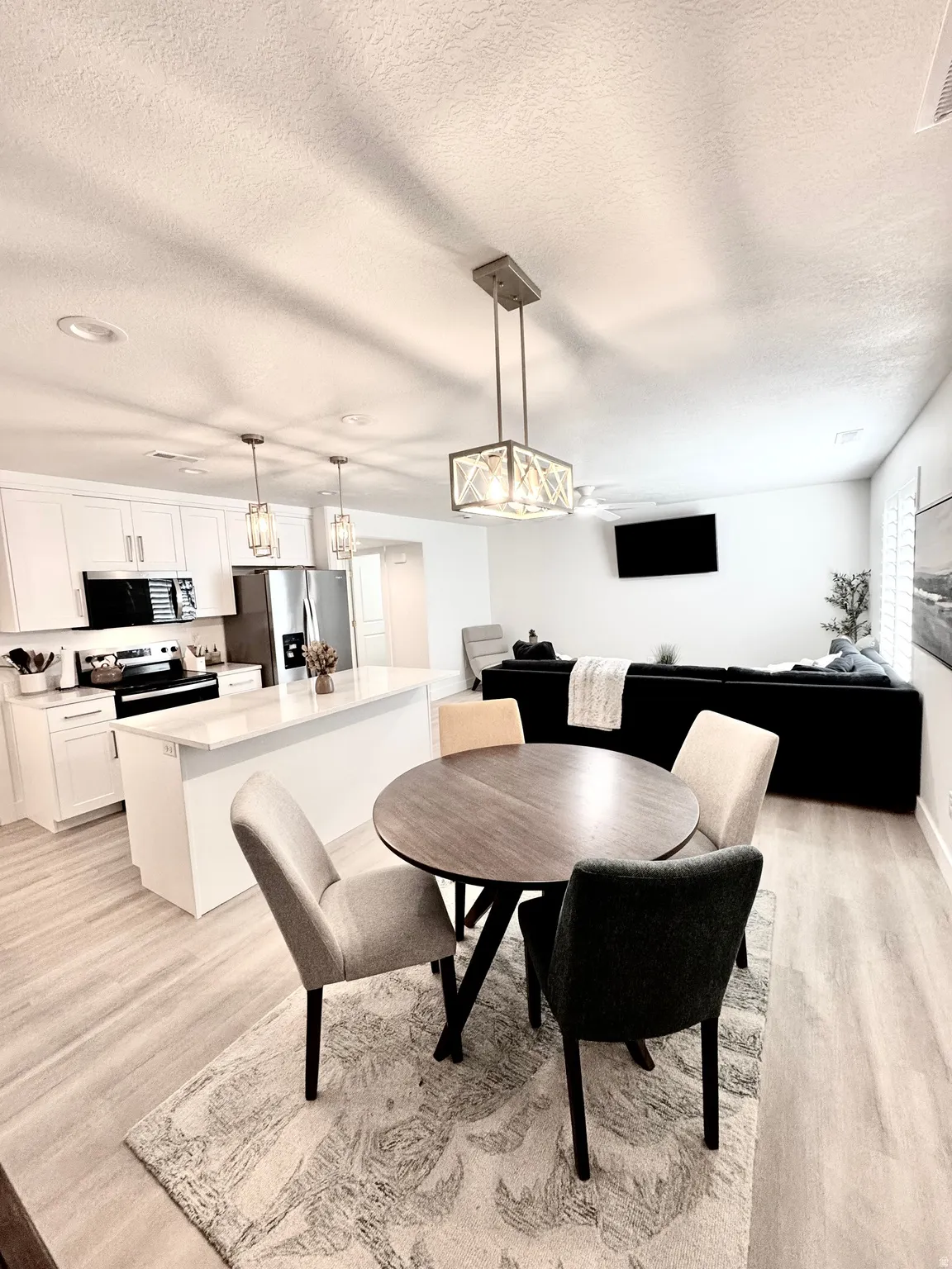 Open concept living area featuring wood-finish flooring, recessed lighting, and a modern rectangular chandelier