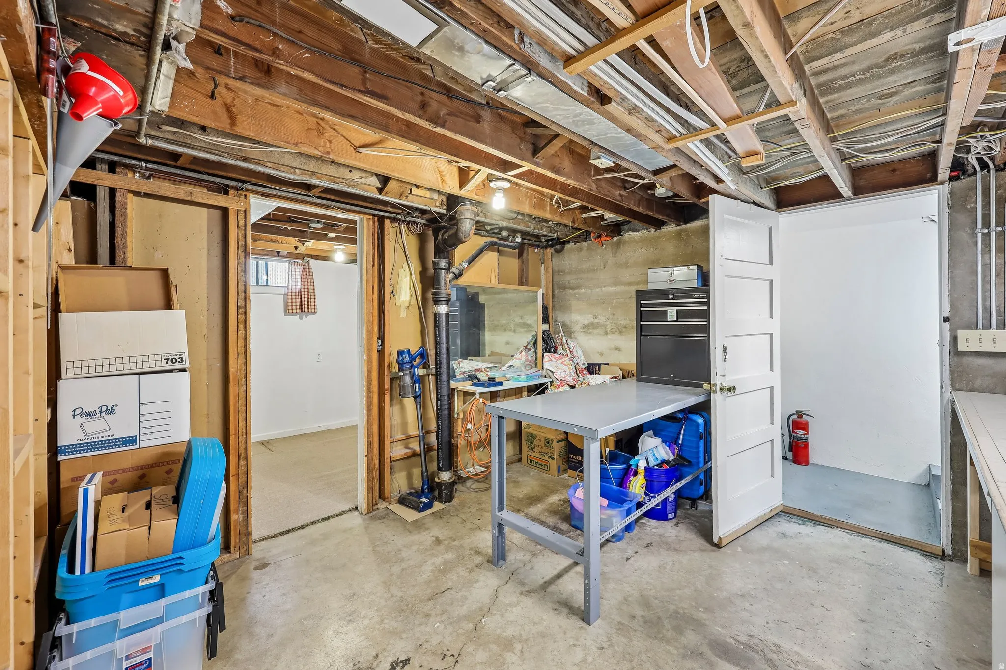 Exposed wood beam ceiling, concrete flooring, and built-in shelving