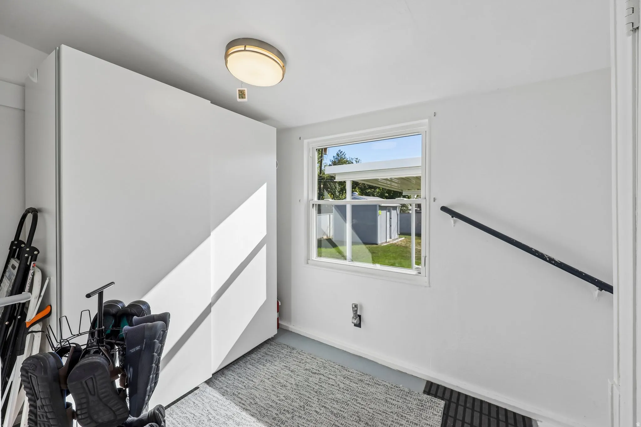 White walls with built-in storage, a single window, and a wall-mounted handrail