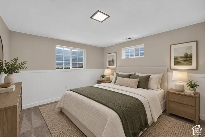 Neutral wall tones, white paneling, multiple windows, and carpet flooring create a comfortable atmosphere