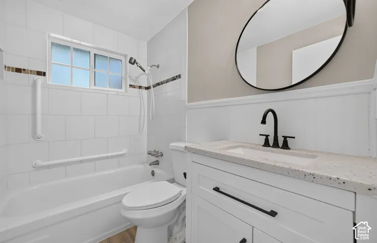 White tiled shower and tub combination with decorative accent tile