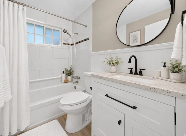 White shaker-style vanity with matte black hardware, integrated sink, and speckled countertop