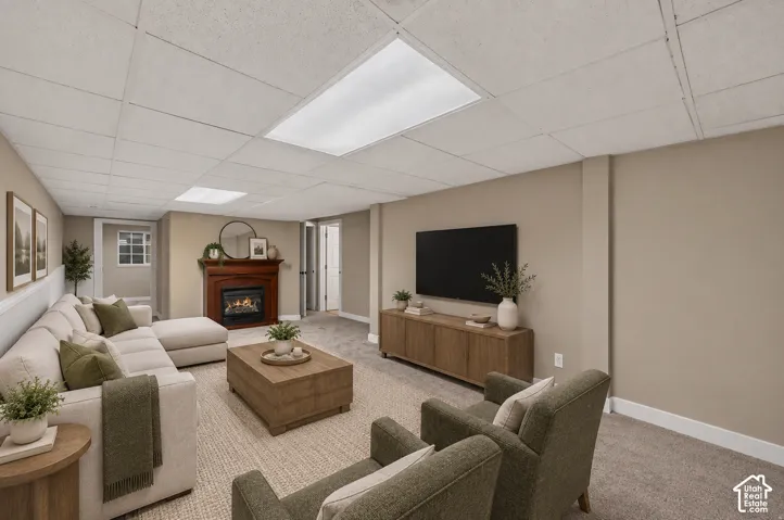 Recessed lighting, drop ceiling, gas fireplace with wood mantel, carpeted flooring, and neutral wall tones