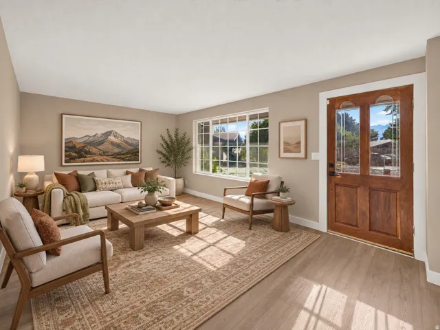 Wood-finish flooring throughout, framed window with grid pattern, solid wood entry door with decorative glass panels, neutral wall tones, and recessed lighting