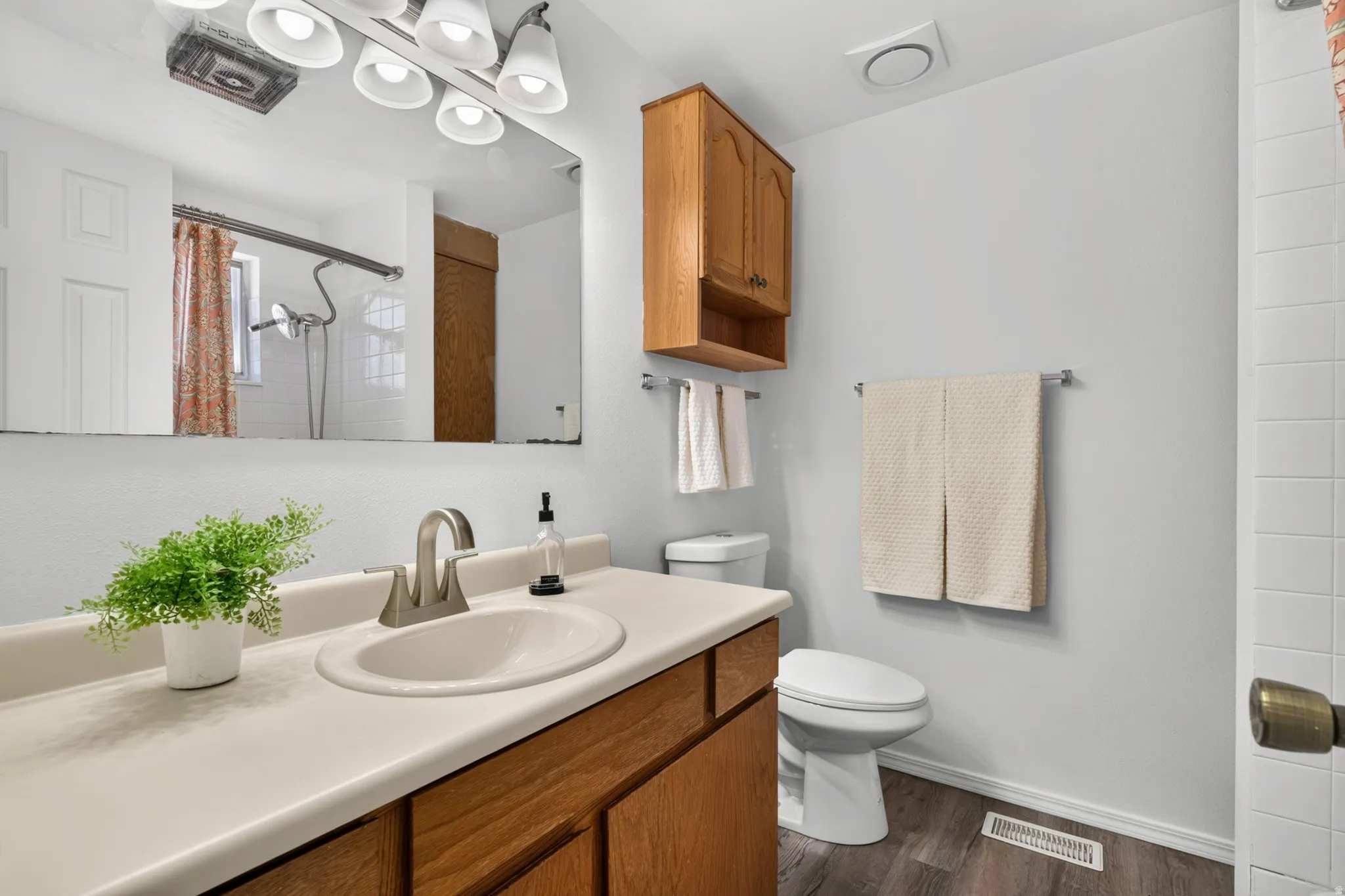 Built-in vanity with a single basin sink, brushed nickel faucet, and wood-finish cabinetry