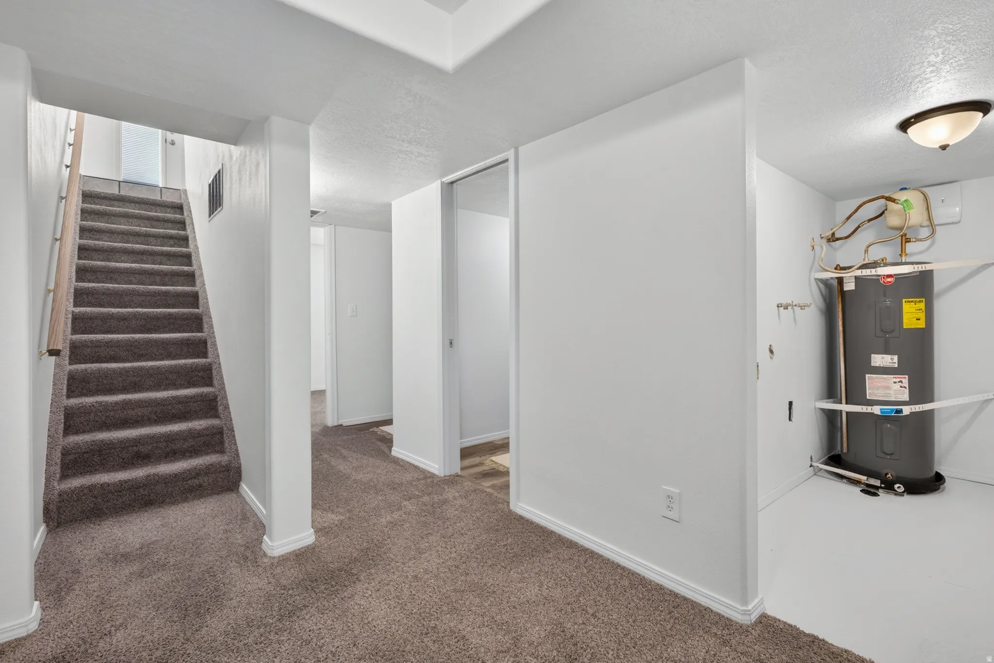 Carpeted staircase with wooden handrail