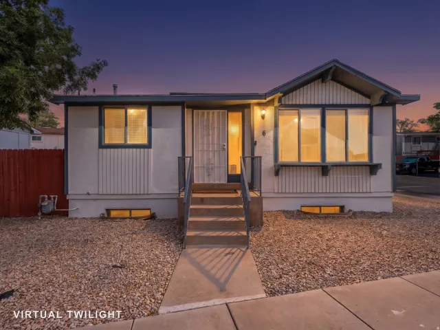 Siding exterior with a covered entry, concrete steps, and a metal handrail