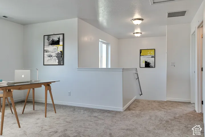 Carpeted flooring throughout, recessed ceiling lighting, light-filled window, and neutral wall tones