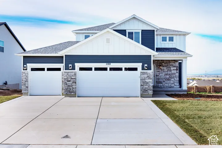 Contemporary exterior with a two-car garage, stone accents, and a covered entry