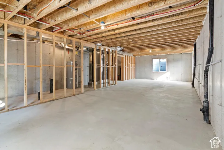 Expansive unfinished basement featuring concrete flooring and a framed wall structure