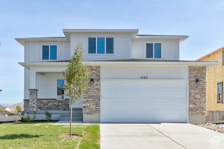 Modern two-story exterior with a two-car garage, stone and siding facade, and a covered entryway