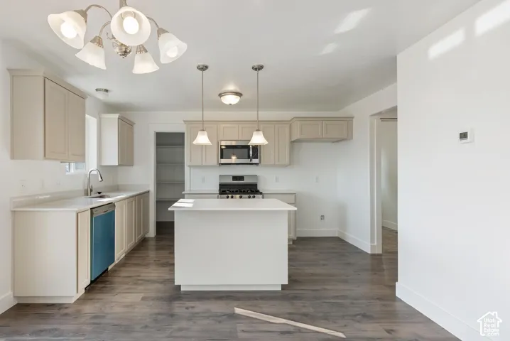 Kitchen featuring a central island, light-toned cabinetry, stainless steel appliances, and wood-finish flooring