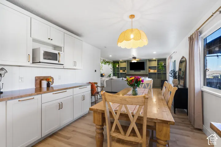 White shaker cabinetry with gold-tone hardware, wood-finish flooring, and recessed lighting