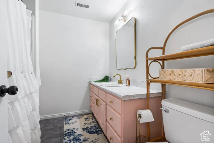 Vanity with integrated sink, gold-tone faucet, and white countertop