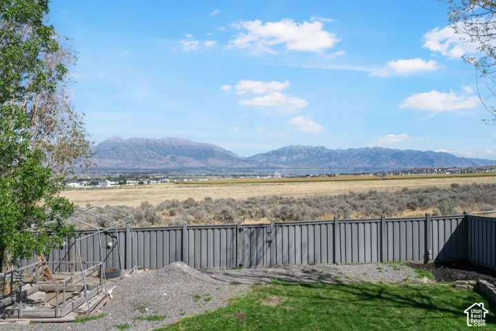 Expansive backyard with a manicured lawn, gravel area, and a solid perimeter fence