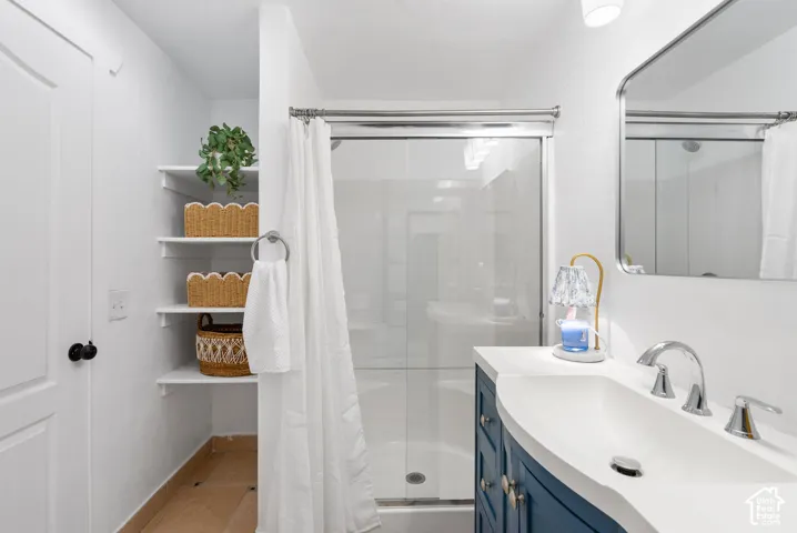 White built-in shelving, blue vanity with an integrated sink, polished chrome faucet, and a wall-mounted mirror