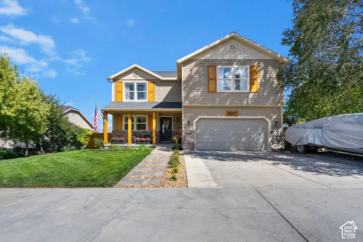 Two-story residence featuring a covered front porch, attached two-car garage, and a concrete driveway